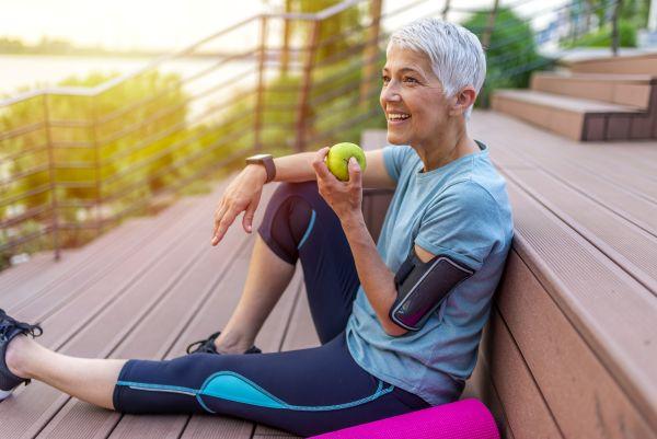 norh york woman holding green apple sitting on her deck